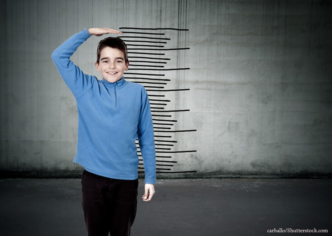 child measuring height - growth chart - carballo/Shutterstock.com