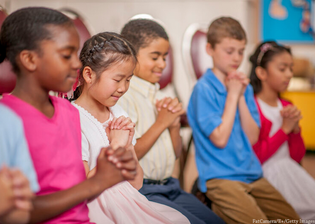young children praying - FatCamera/E+/Getty Images